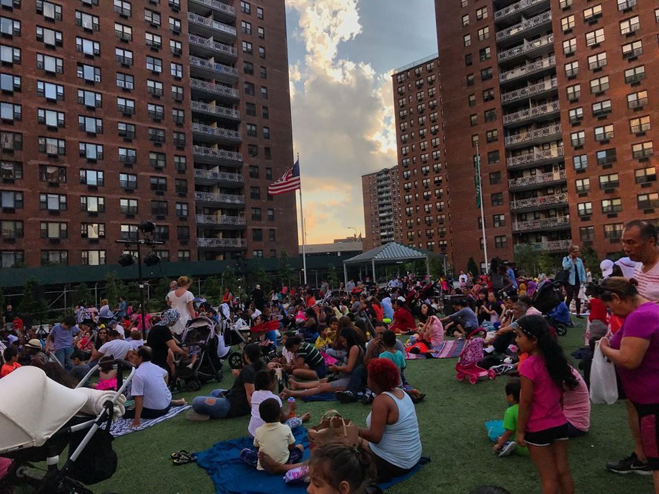 Residents of all ages watching Shakespeare in the Park - LeFrak City's community event