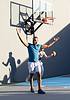 Residents playing basketball on an outdoor court, with one person celebrating and another holding the ball