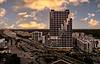 Cascade Link at Douglas apartment building at sunset, towering over the surrounding cityscape with a dramatic sky in the background