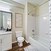 bathroom with soaking tub and white cabinets