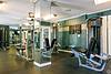 A gym interior featuring weight machines and mirrors, with equipment neatly arranged in a well-lit space.