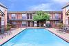 pool at la estancia apartments with brick buildings surrounding it