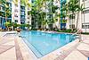 Swimming pool with seating on sundeck and trees