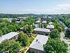 Exterior of Towne Estates Apartments - three story red brick building with landscaping and trees on a sunny day.