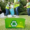 outdoor photo of recycling bin with a group of people in the background picking up trash