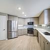 modern kitchen with gray cabinets, stainless steel appliances, and quartz countertops