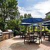 Courtyard with grills and chairs and tables with blue umbrellas