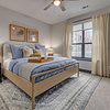 Apartment bedroom with bed, side table, and lamps