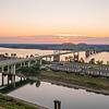 highway over river at sunset near apartment buildings