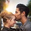 man kissing a woman on her forehead