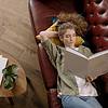Woman reading book on red couch