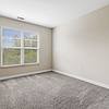 Carpeted bedroom with two large windows at Realm at Patterson Place.