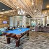 Resident game room with Billiards with wooden floors and stylish turquoise furniture at Patterson Place Apartments.