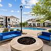 Fire pit lounge with outdoor sofas and side tables at Patterson Place Apartments.