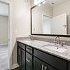 Bathroom with grey, granite countertops, and dark-colored cabinetry at Realm at Patterson Place.