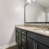 Bathroom with granite countertops and dark-colored cabinetry at Realm at Patterson Place.