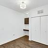 room with closet access, office access, white walls and wood flooring