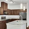 kitchen equipped with stainless steel appliances, large countertops, a floating island, wood cabinets