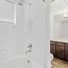 Spacious bathroom with storage, a shower/tub combo, and large countertops