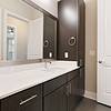 Modern bathroom with dark-colored cabinetry, quartz countertops, 10-12-foot ceilings, and silver hardware at Bullhouse.