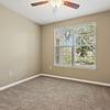 Carpeted bedroom with ceiling fan and window