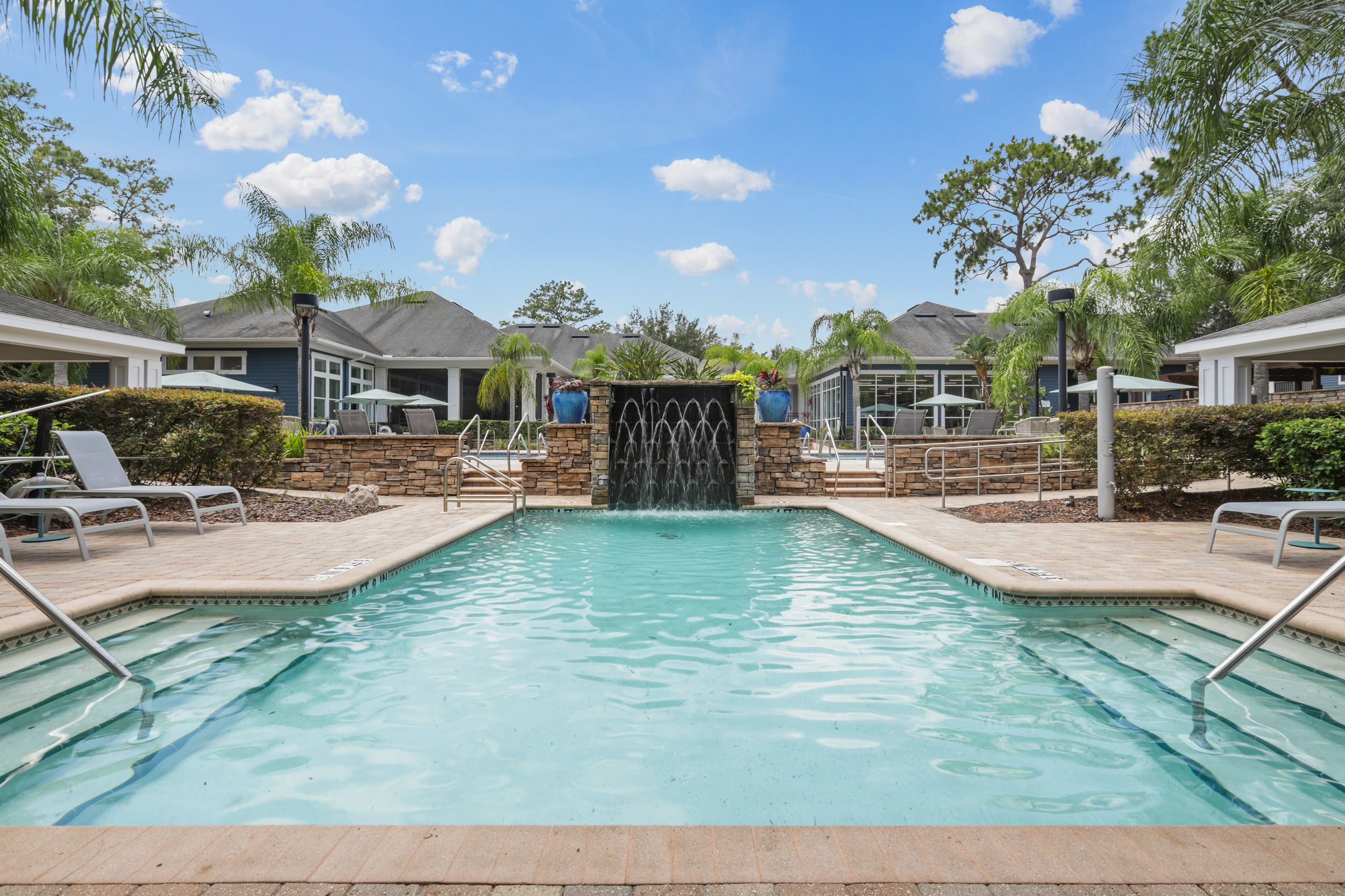 resort-style pool and hot tub with sundeck and lounge chairs