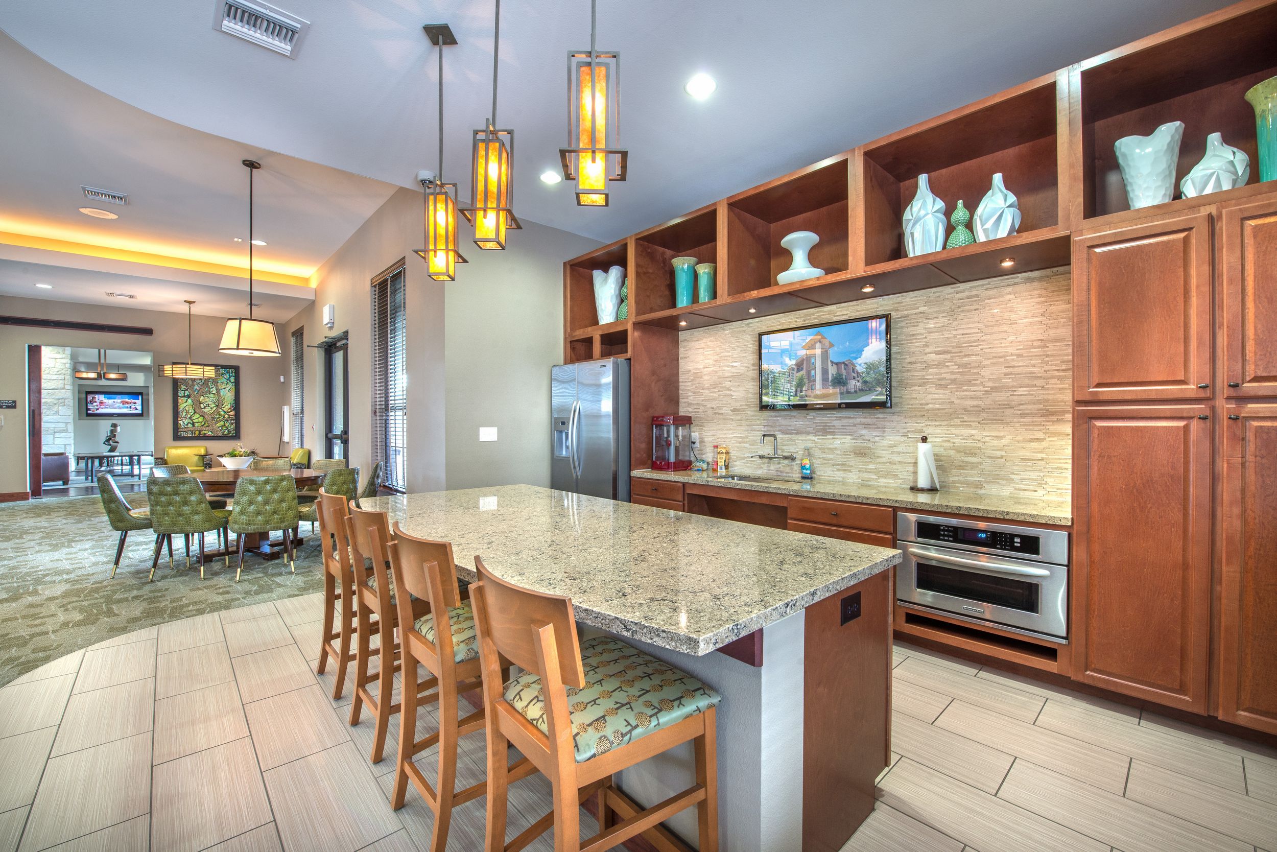 Community kitchen with stainless steel appliances and island with seating at Lantower Residences at the Collection