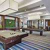  Lounge with a billiard table, arcade games, and shuffleboard.