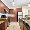 kitchen with glossy countertops, stainless steel appliances, and wood cabinets at Lantower The Cortona