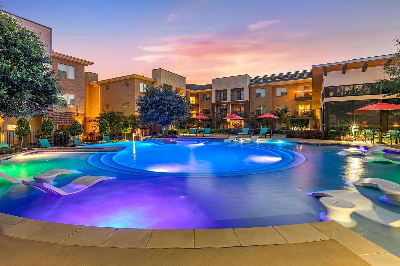 Resort style swimming pool with lighting at dusk at Lantower Legacy Lakes
