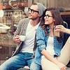 Couple drinking coffee outside shop