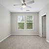 Carpeted bedroom at Lantower Garrison Park with two large windows and a ceiling fan.