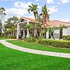 Lush landscaping with palm trees, green grass, and tropical foliage at Tortuga Bay Apartments in Orlando, FL.	