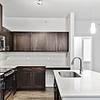 kitchen with white quartz countertops, stainless steel sink basin, stainless steel appliances, and an island with overhead lighting at Lantower Techridge apartments