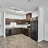 Open and spacious kitchen and living room with dark cabinets and black stainless steel appliances at Lantower Techridge apartments