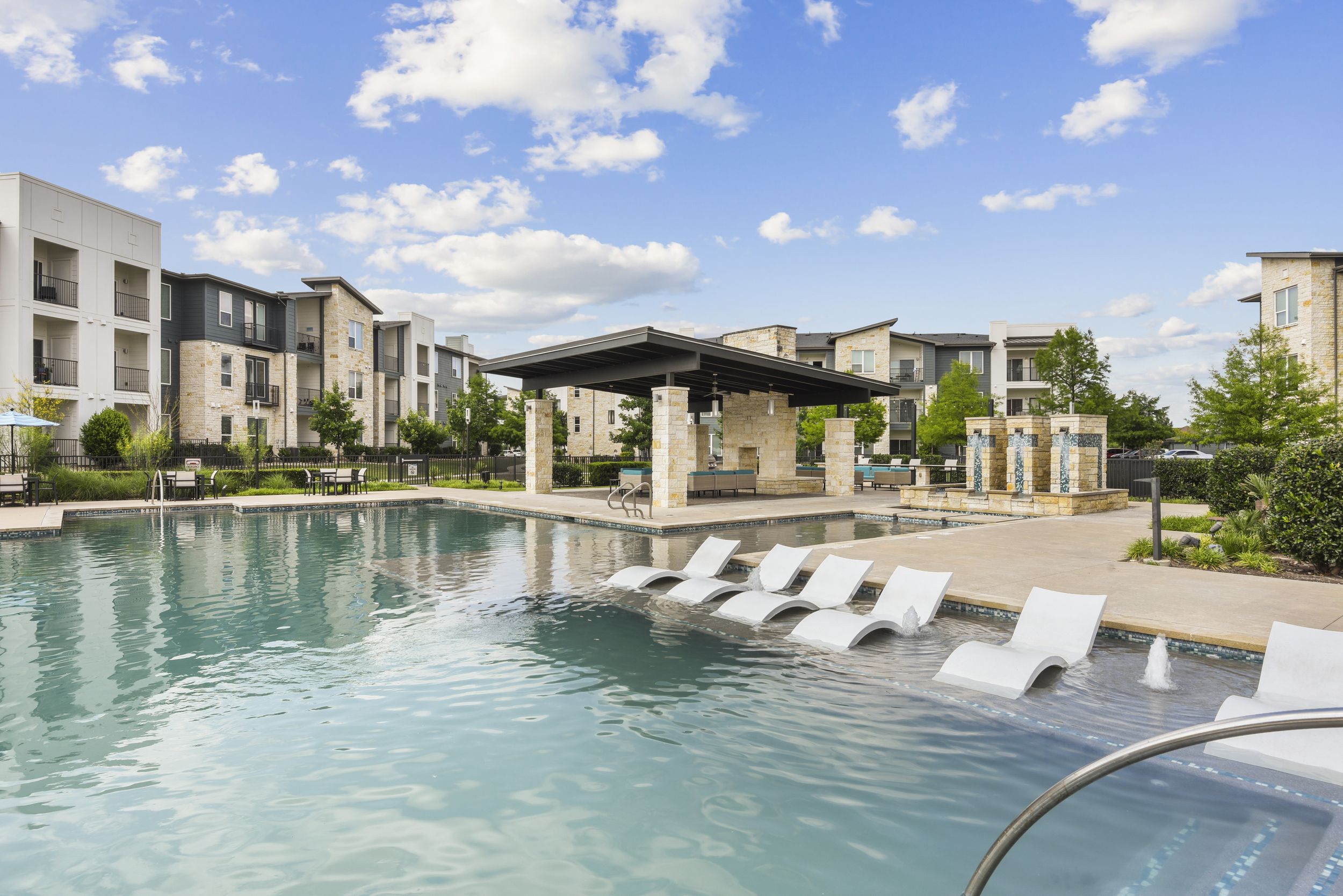 Resort-style swimming pool with a deck and seating at Lantower Techridge apartments