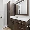 Modern bathroom with dark-colored cabinetry, quartz countertops, 10-foot ceilings, and silver hardware at Lantower Weston Corners.