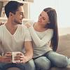 Couple siting on couch drinking coffee