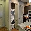 Stackable washer and dryer in utility closet near kitchen
