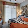 Bedroom with large window and rustic wood headboard