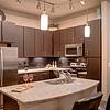 Kitchen island with light gray granite countertop and stainless steel appliances