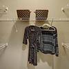 Walk in closet with white wire shelving and clothing on hangers