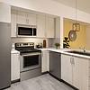 Apartment kitchen with stainless steel appliances and light cabinetry