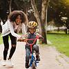Woman teaching child to ride a bike
