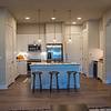 Open kitchen with designer lighting, wine fridge and kitchen island