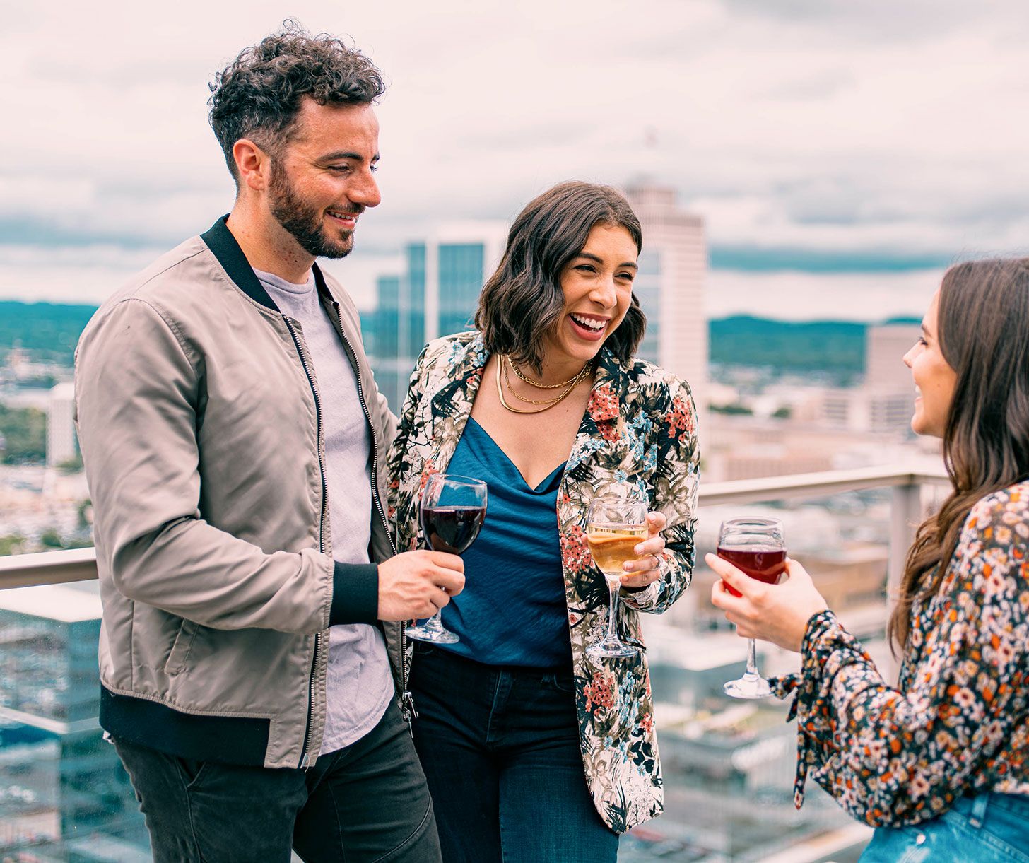Group of people talking with drinks on rooftop