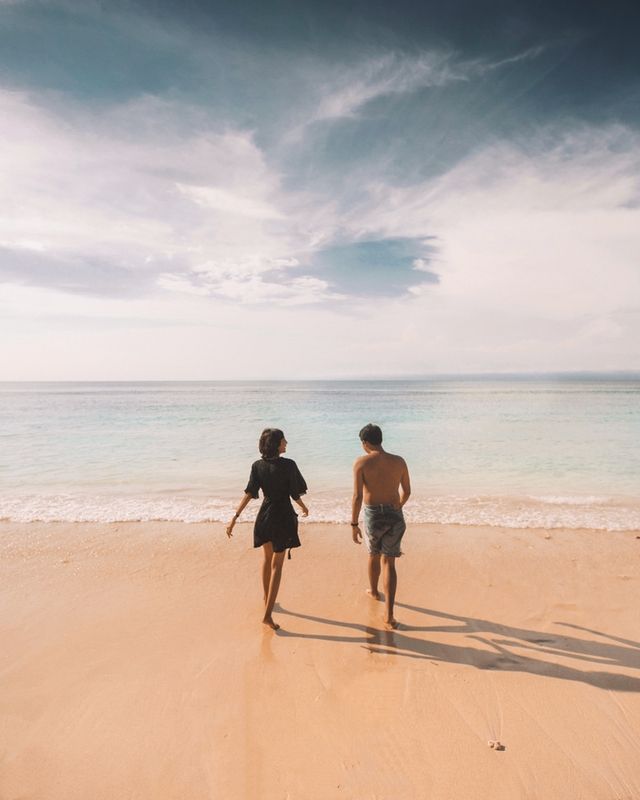 Couple walking toward water at beach