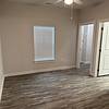 Unfurnished bedroom with hard flooring, ceiling fan, and windows