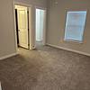 Unfurnished bedroom with carpet and windows