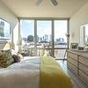 Bedroom with hard flooring, ceiling fan, and city view